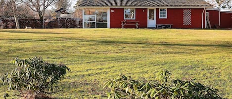 A red building with a number '10' on the side, a glass door, and a small patio area.