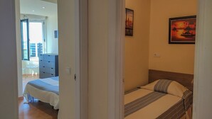 Ein Schlafzimmer mit zwei Betten, einem Schminktisch und einem Bild an der Wand.