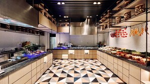 Una cocina moderna con suelo de estampado geométrico, electrodomésticos de acero inoxidable y presentaciones de alimentos ordenadas.