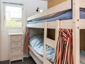 A bunk bed room with a window, a small white cabinet, and striped curtains. - 6 Person Holiday Home in Juelsminde-by Traum (Juelsminde)