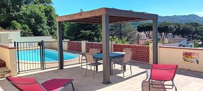 A rooftop terrace with a pool, outdoor seating, and a pergola.