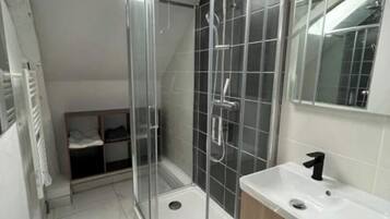 Een douche, een haardroger, handdoeken, toiletpapier