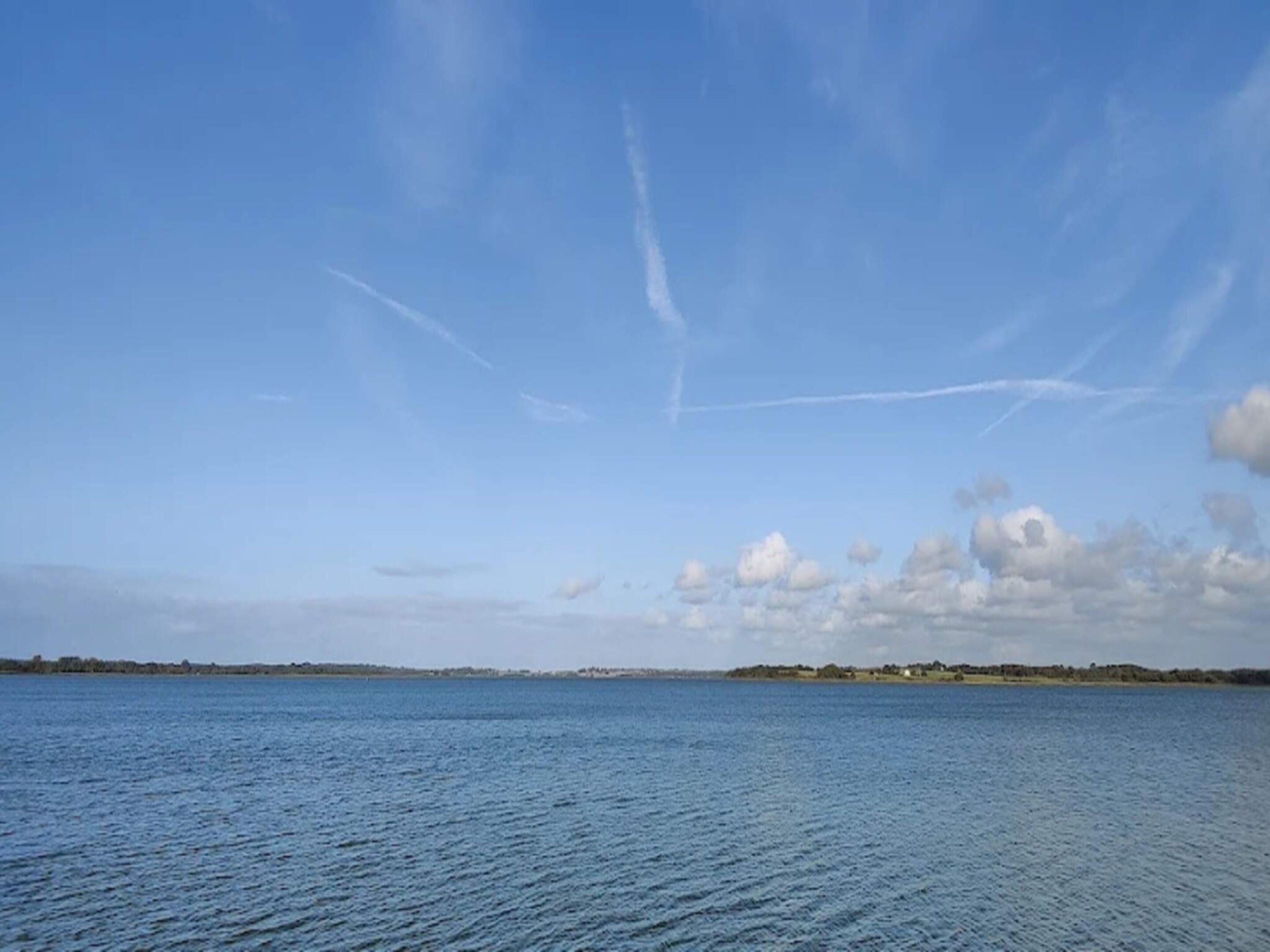 A calm body of water with a clear sky and distant land.