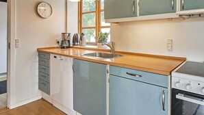 A kitchen with a wooden countertop, a sink, a dishwasher, a stove, and cabinets. - 12 Person Holiday Home in Aakirkeby (Akirkeby)