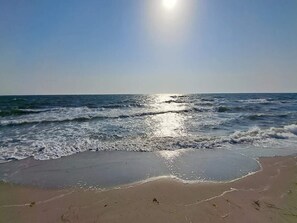 Uma praia com ondas e céu claro.