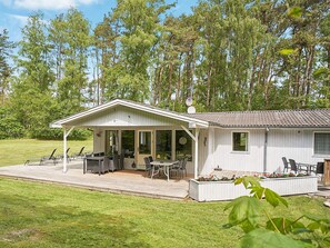 A single-story cabin with a covered patio, outdoor seating, and a small garden area. - 6 Person Holiday Home in Nexo (Nexø)