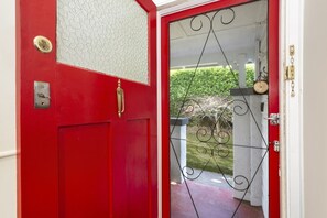 A red door with a brass handle, a glass panel, and a metal gate. - Allambee Cottage - pet friendly, close to town & the station (Katoomba)