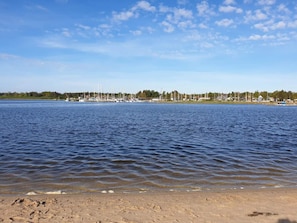 A calm body of water with boats and a marina in the background.