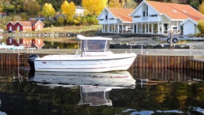 A white boat docked at a pier with a forested hillside in the background. - 8 Person Holiday Home in Jelsa (Suldal)