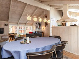 A dining area with a round table, chairs, and hanging spherical light fixtures.