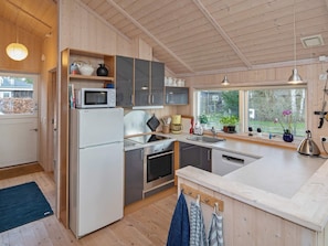A modern kitchen with a refrigerator, microwave, oven, and sink. - 4 Star Holiday Home in Vaeggerlose (Vaeggerlose)