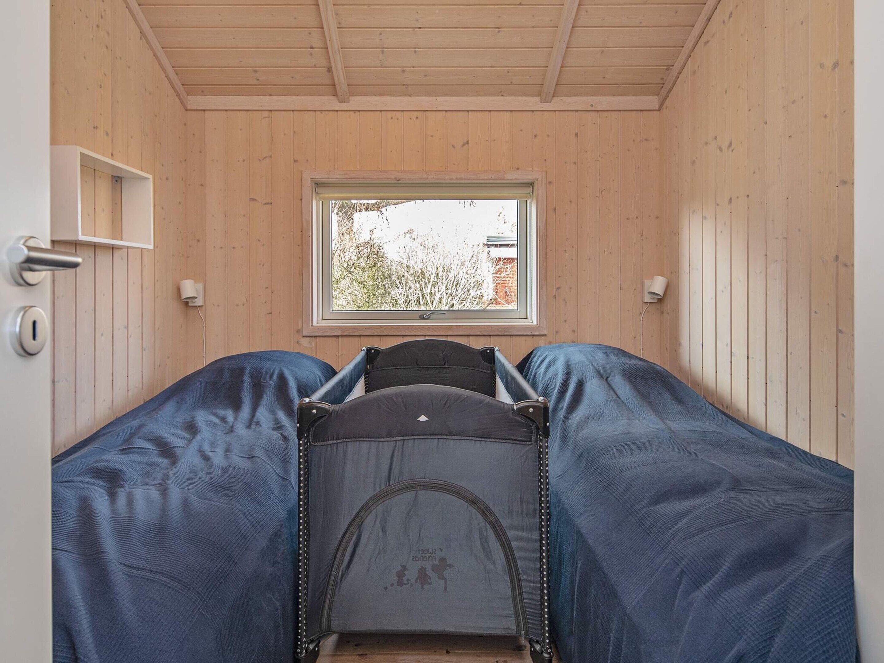 A compact room with a bed, a window, and a door.