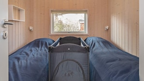 A compact room with a bed, a window, and a door. - 4 Star Holiday Home in Vaeggerlose (Vaeggerlose)