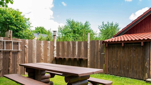 A picnic table with benches in a backyard. - 6 Person Holiday Home in Hovborg (Hovborg)