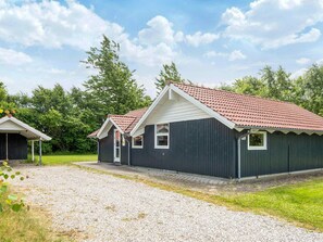 A two-story building with a red-tiled roof and a gravel driveway.