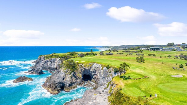A coastal golf course with a rocky coastline, a clear view of the ocean, and a well-maintained green. - 12 Bluewater Drive Narooma (Narooma)