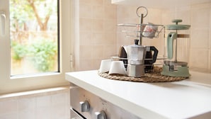 A kitchen with a stove, a coffee maker, and a blender on the counter. - Luigi's room Sorrento (Meta)