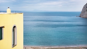 A coastal building with a clear view of the sea and a distant mountain range. - Luigi's room Sorrento (Meta)