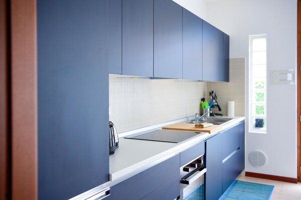 A modern kitchen with blue cabinets, a white countertop, and a built-in oven. - Blue Bellagio by Wonderful Italy (Bellagio)