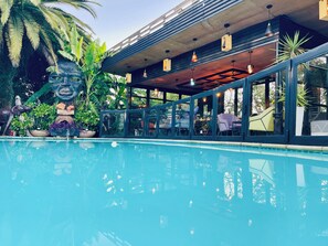 A poolside area with lounge chairs, a covered seating area, and a large decorative sculpture. - 24 On Basil Boutique Luxury Hotel (Randburg)