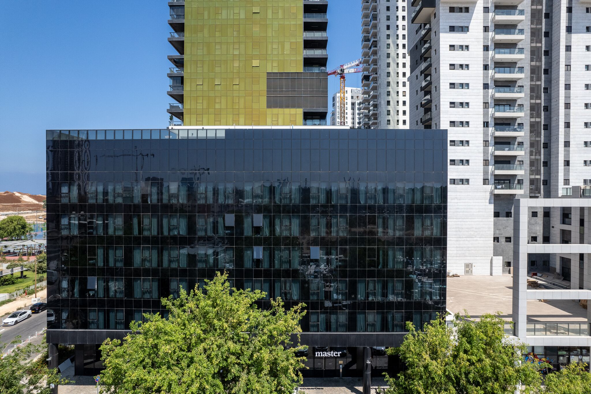 A modern building with a glass facade, surrounded by other high-rise buildings.