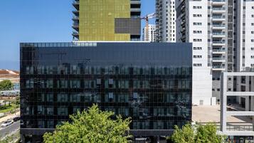 A modern building with a glass facade, surrounded by other high-rise buildings.