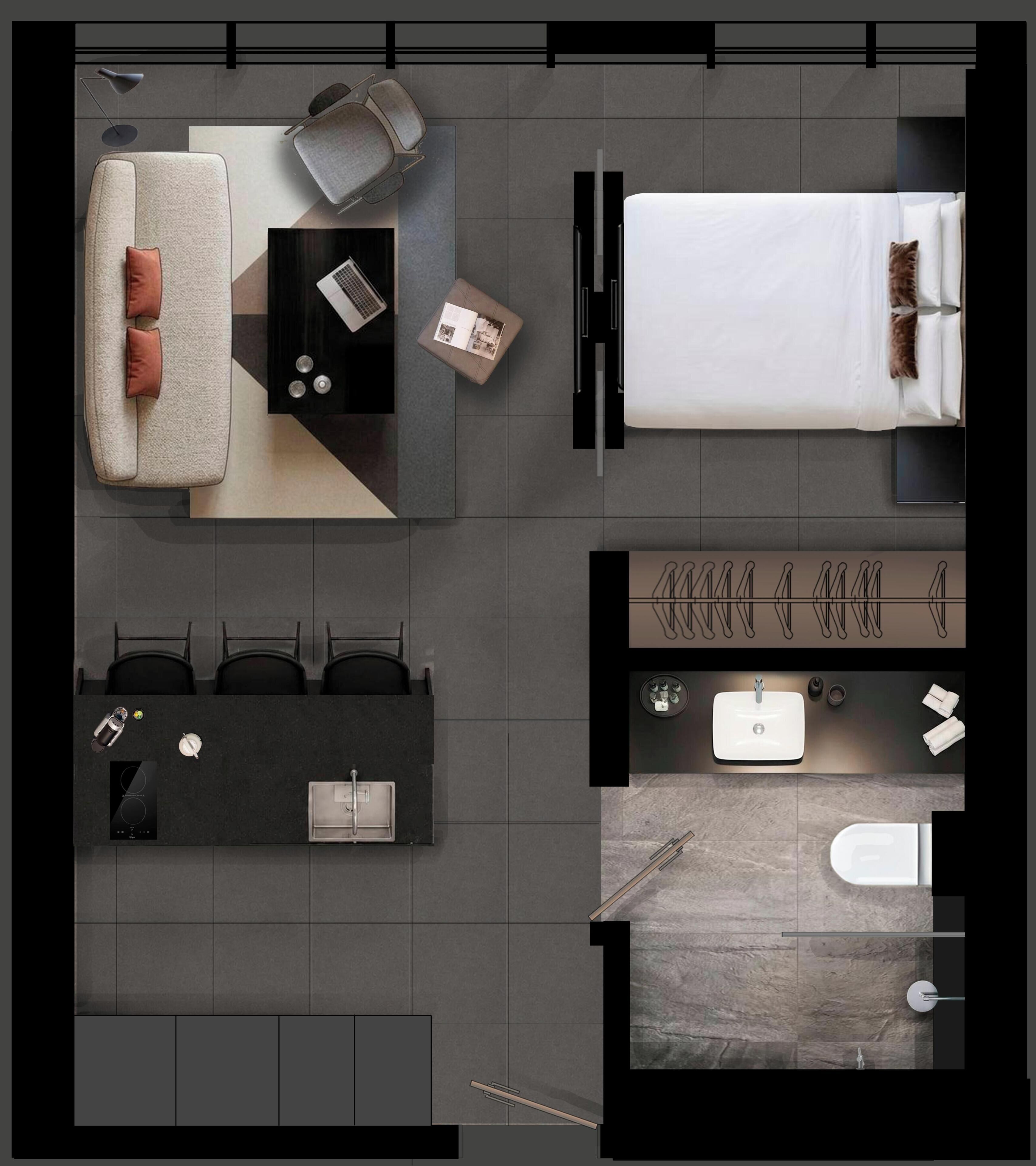 A modern hotel room with a bed, a sofa, a desk with a laptop, a small table with a book, a bathroom with a sink, toilet, and shower.