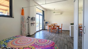 Una habitación con una cama, un escritorio, una silla, un televisor y una ventana.