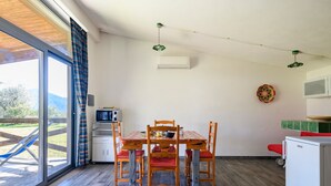 Un comedor con una mesa y sillas de madera, un microondas y un refrigerador.