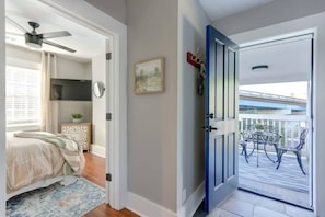 Relax in this serene hotel room with a comfortable bed, a potted plant, and a balcony offering a view of a bridge and lush surroundings.