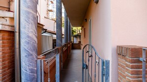 A narrow alleyway with a metal gate, brick walls, and a tiled floor. - Holiday Apartment 'Aria' close to the Beach with Shared Terrace & Balcony (Follonica)