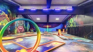 An indoor play area with colorful murals, a large circular structure, and various play equipment. - 5 Star Holiday Home in Wendtorf (Wendtorf)