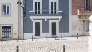 Ein Gebäude mit einer grauen Fassade, weißem Zierdekor und einem Balkon mit Metallgeländern.