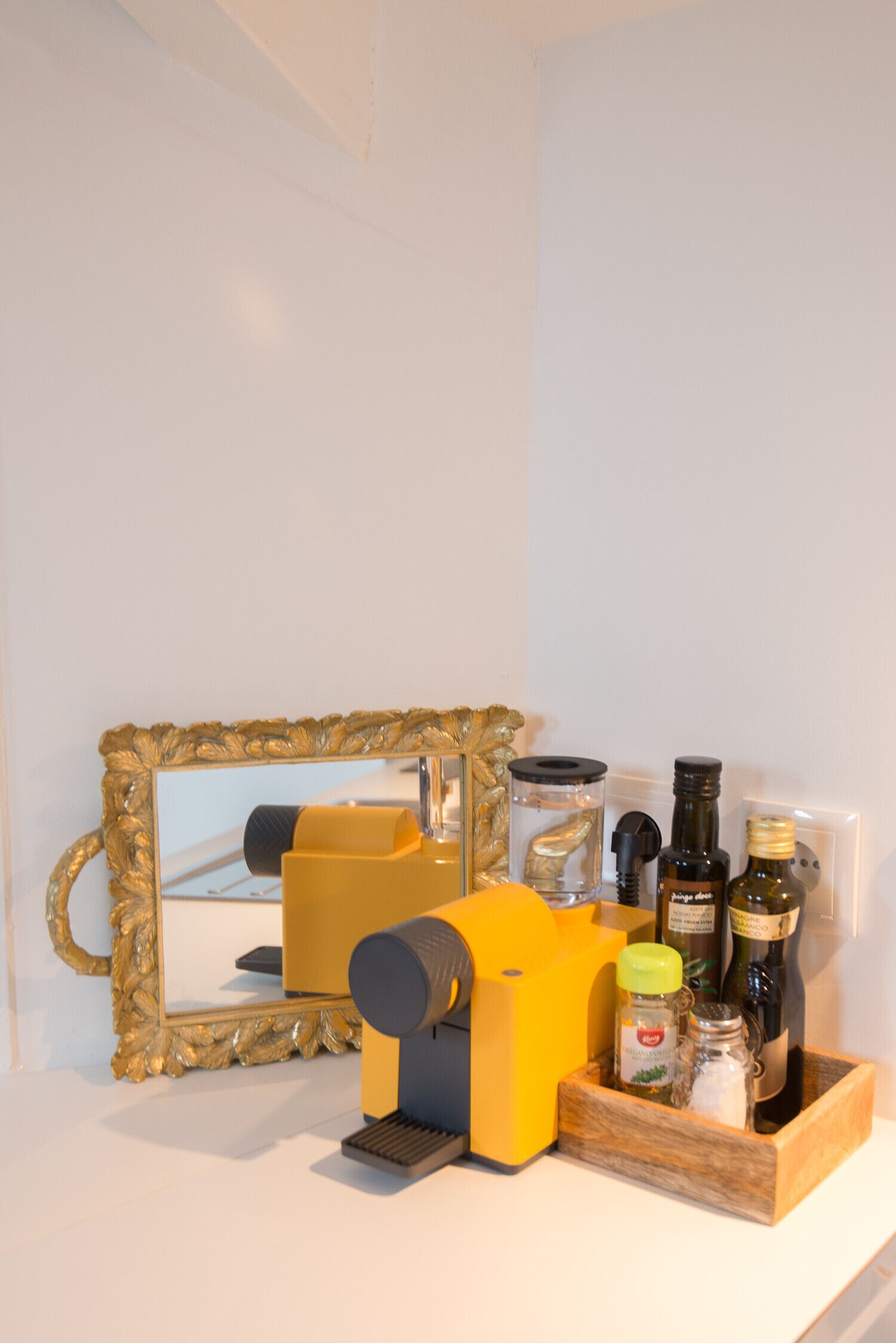 Un meuble-lavabo de salle de bain avec un miroir, un distributeur de savon jaune et divers produits de toilette.