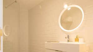 A modern bathroom with a white sink, mirror, and toilet. - CASASUPERTUBOS - APART 11 (Peniche)