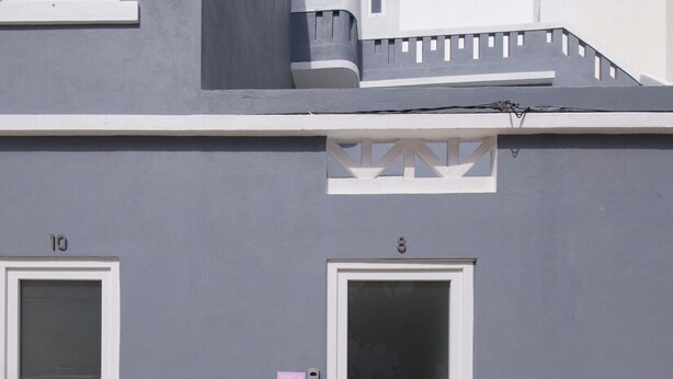 A building with two doors, one marked with the number 10, and a small window above the door. - CASASUPERTUBOS - APART 11 (Peniche)
