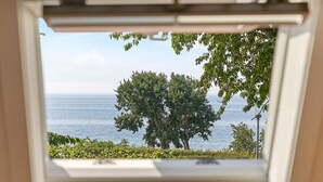 A window with a view of the sea and trees. - 6 Person Holiday Home in Aakirkeby (Akirkeby)