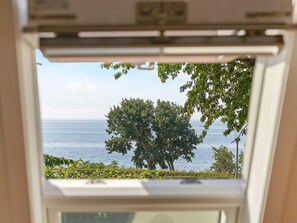 A window with a view of the sea and trees. - 6 Person Holiday Home in Aakirkeby (Akirkeby)