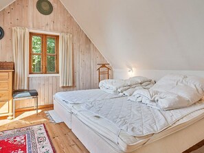 A bedroom with a bed, a chair, a window, and a dresser. - 6 Person Holiday Home in Aakirkeby (Akirkeby)