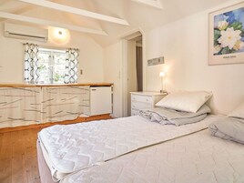 Un dormitorio con cama, mesitas de noche, cómoda y espejo.