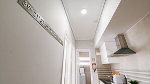 Una cocina moderna con extractor de acero inoxidable, encimera negra y una pequeña planta en maceta.