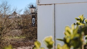 A building with a sign that reads "ENCOSTA D'ORIOS" and a street lamp. - Encosta d'Óbidos T1 (Óbidos)