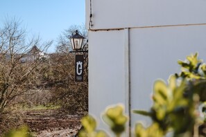 A building with a sign that reads "ENCOSTA D'ORIOS" and a street lamp.