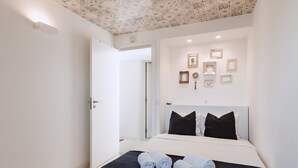 A hotel room with a bed, a black headboard, and a ceiling with a patterned design. - Encosta d'Óbidos T3 (Óbidos)
