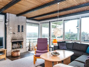 A modern living room with a fireplace, large windows, and a wooden ceiling. - 6 Person Holiday Home in Ronde (Ronde)
