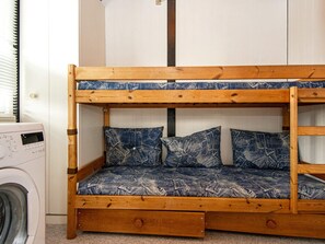 A bunk bed with denim-patterned bedding, a washing machine, and a door in the background. - 6 Person Holiday Home in Ronde (Ronde)