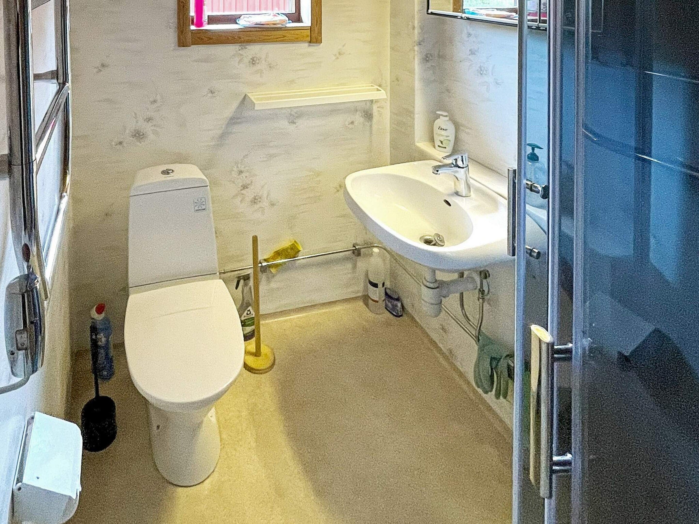 Ett badrum med toalett, handfat och en duschhörna.