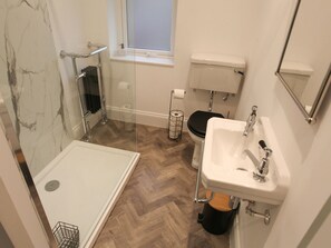 Un baño con ducha, inodoro y lavamanos.