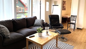 Un salon avec un canapé, un fauteuil, une table basse et une lampe.