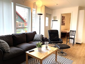 A living room with a sofa, a chair, a coffee table, and a lamp. - 4 Star Holiday Home in Lottorp (Löttorp)
